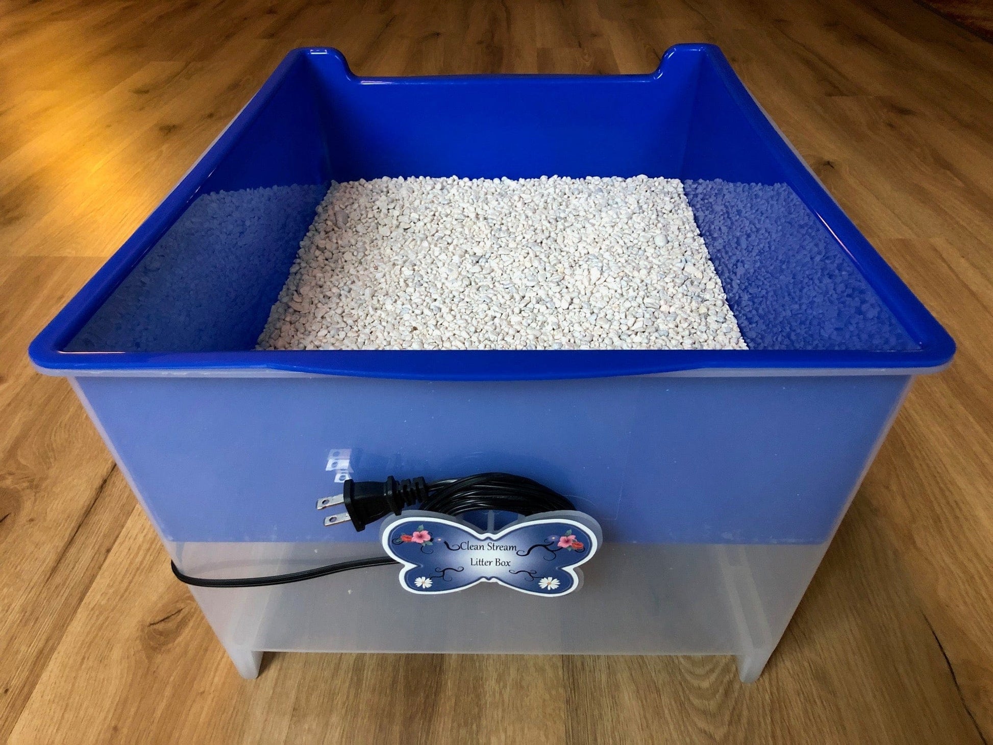 Eco-friendly Clean Stream Litter Box with fish tank gravel on wooden floor.